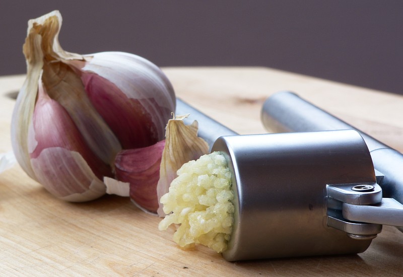 Garlic cloves and garlic press — kitchen ingredient, not a plague treatment