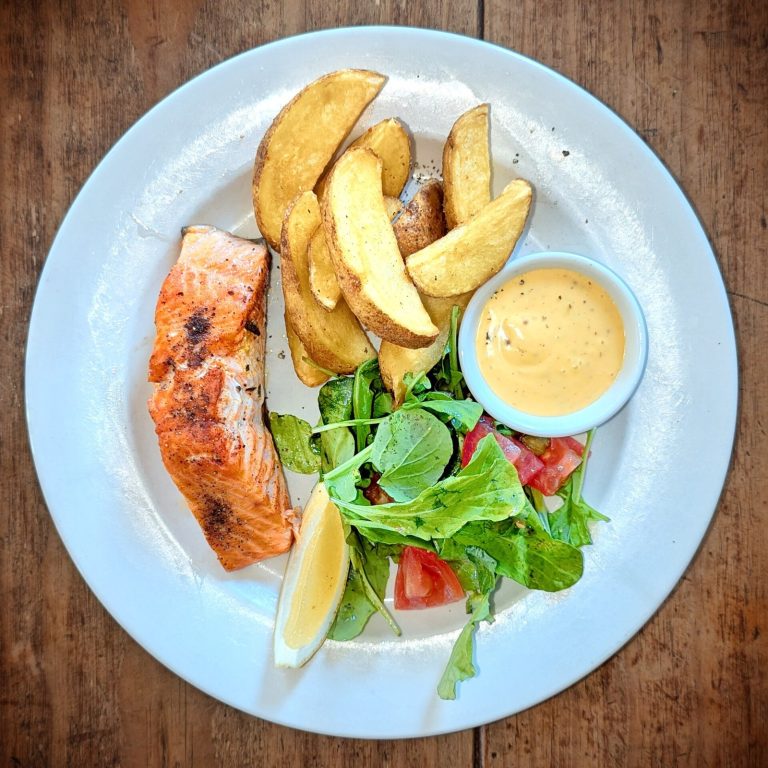 Grilled salmon with potato and salad as a protein-forward rehab meal
