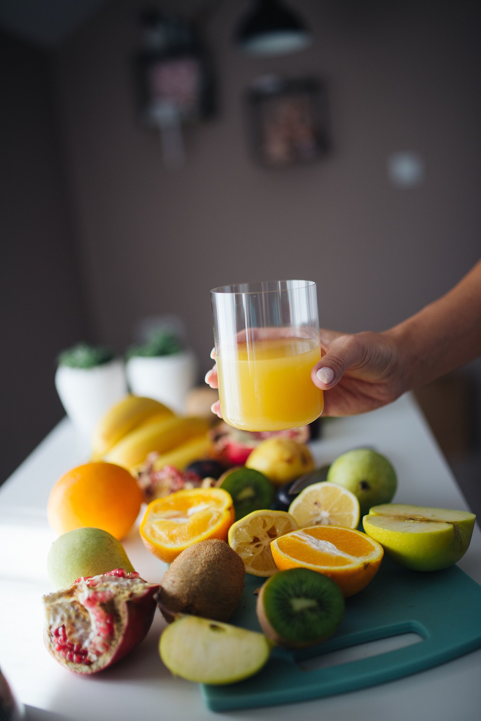 Fresh fruit and orange juice on a kitchen counter as hydration-friendly drinks and foods for UTI support