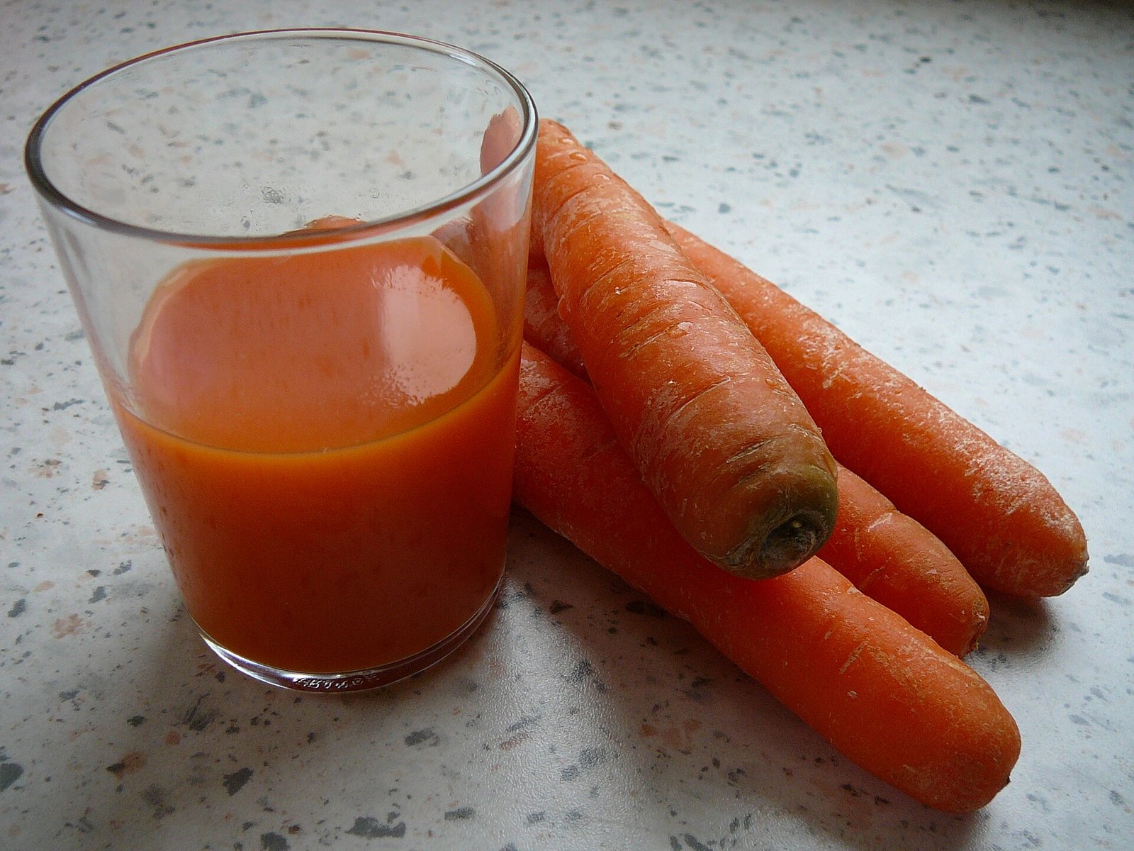 Carrots and juice illustrating food sources of provitamin A carotenoids after cataract surgery