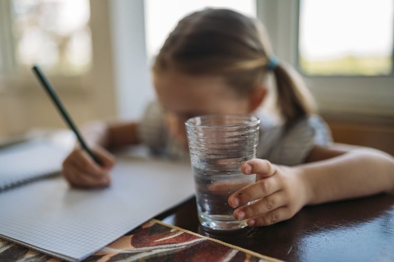 Glass of water on a table as a dry-mouth meal companion