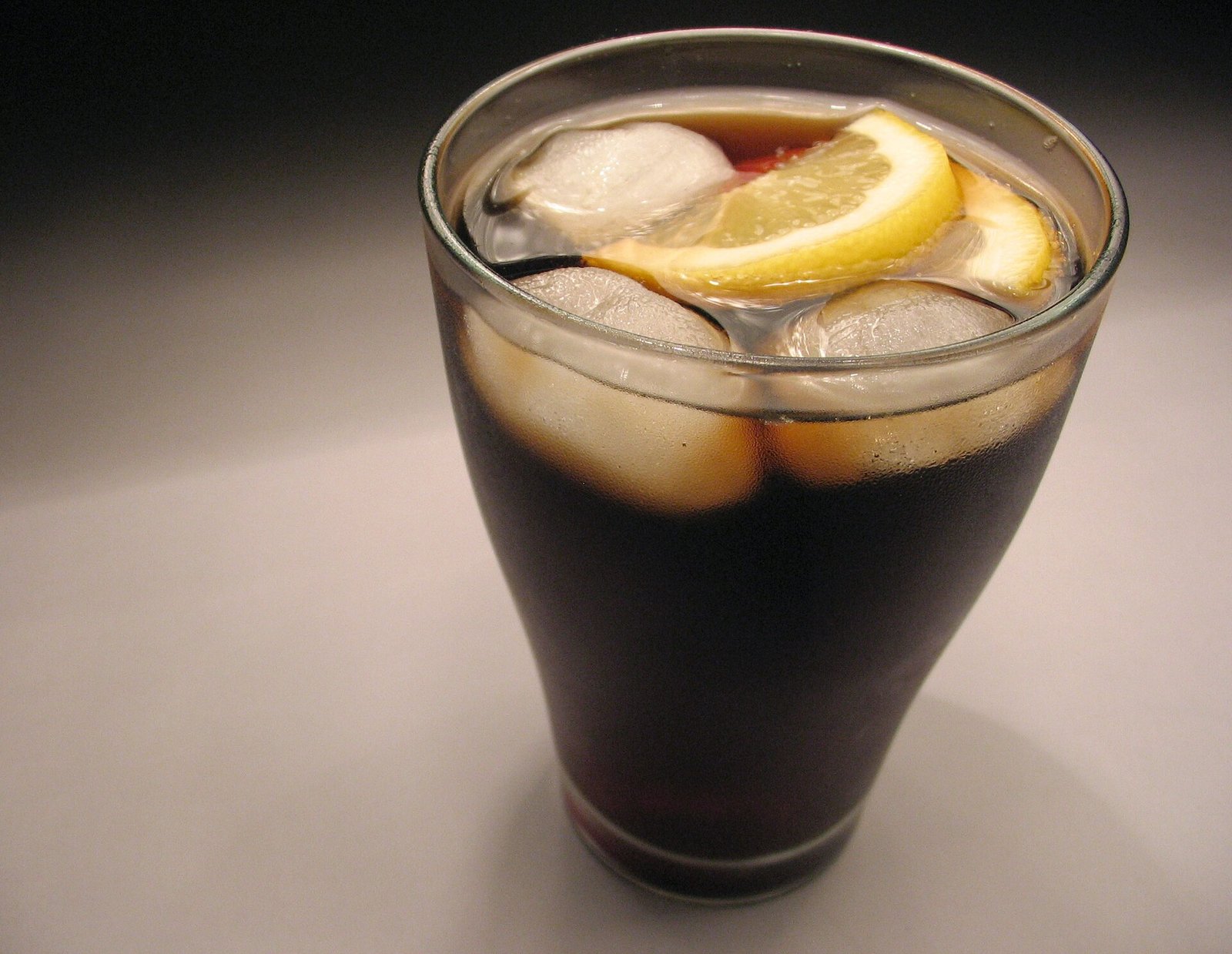 Glass of cola with ice and lemon; fizzy drinks are often avoided on a gastroparesis diet