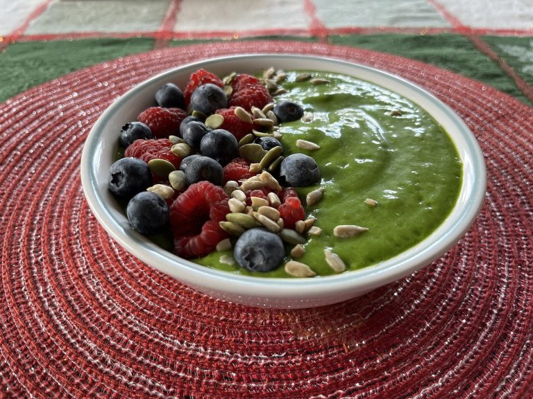 Green smoothie bowl with berries as a planned snack between meals