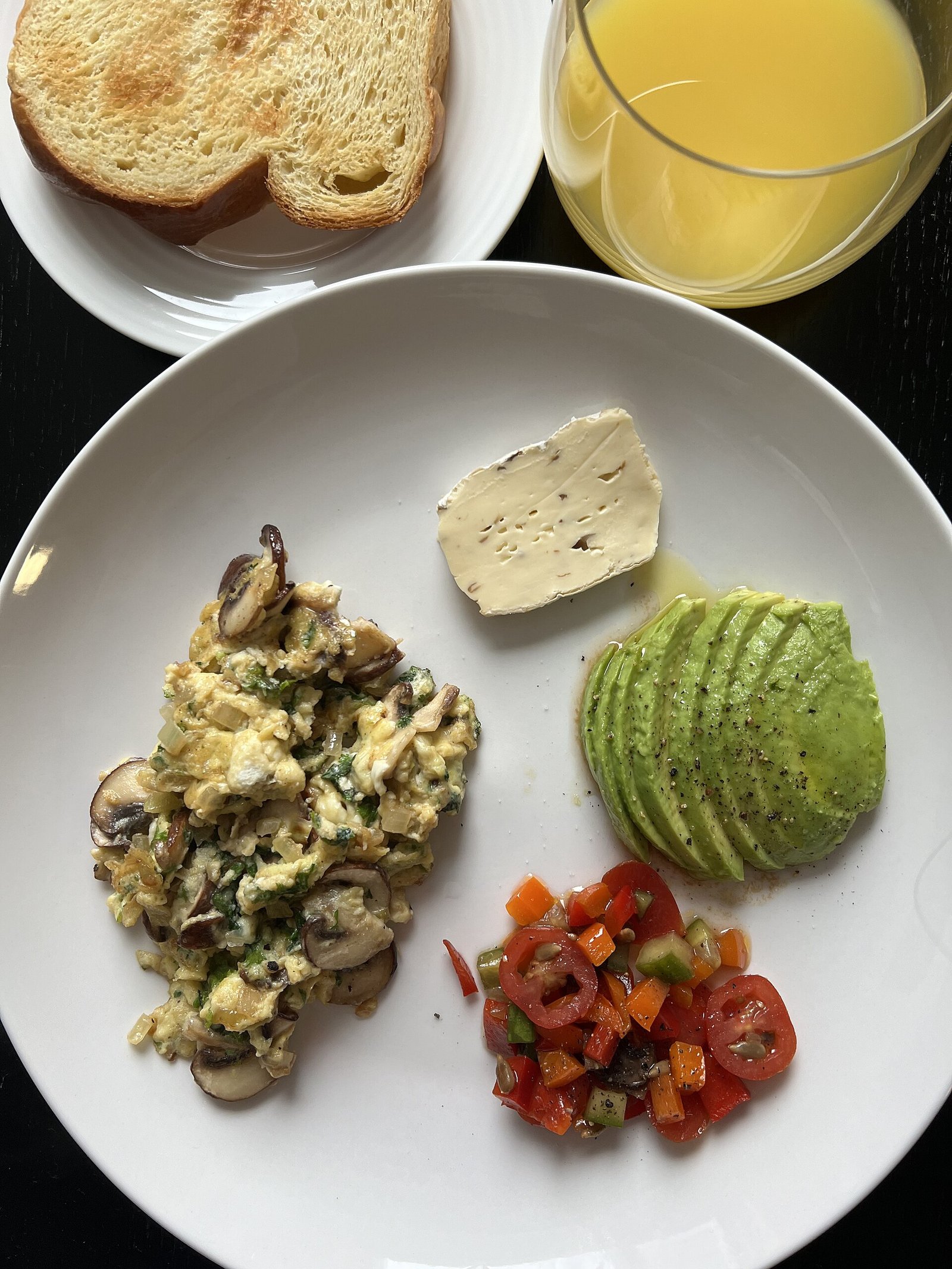 Israeli-style breakfast with scrambled eggs, avocado and tomato salad for a menopause diet morning plate